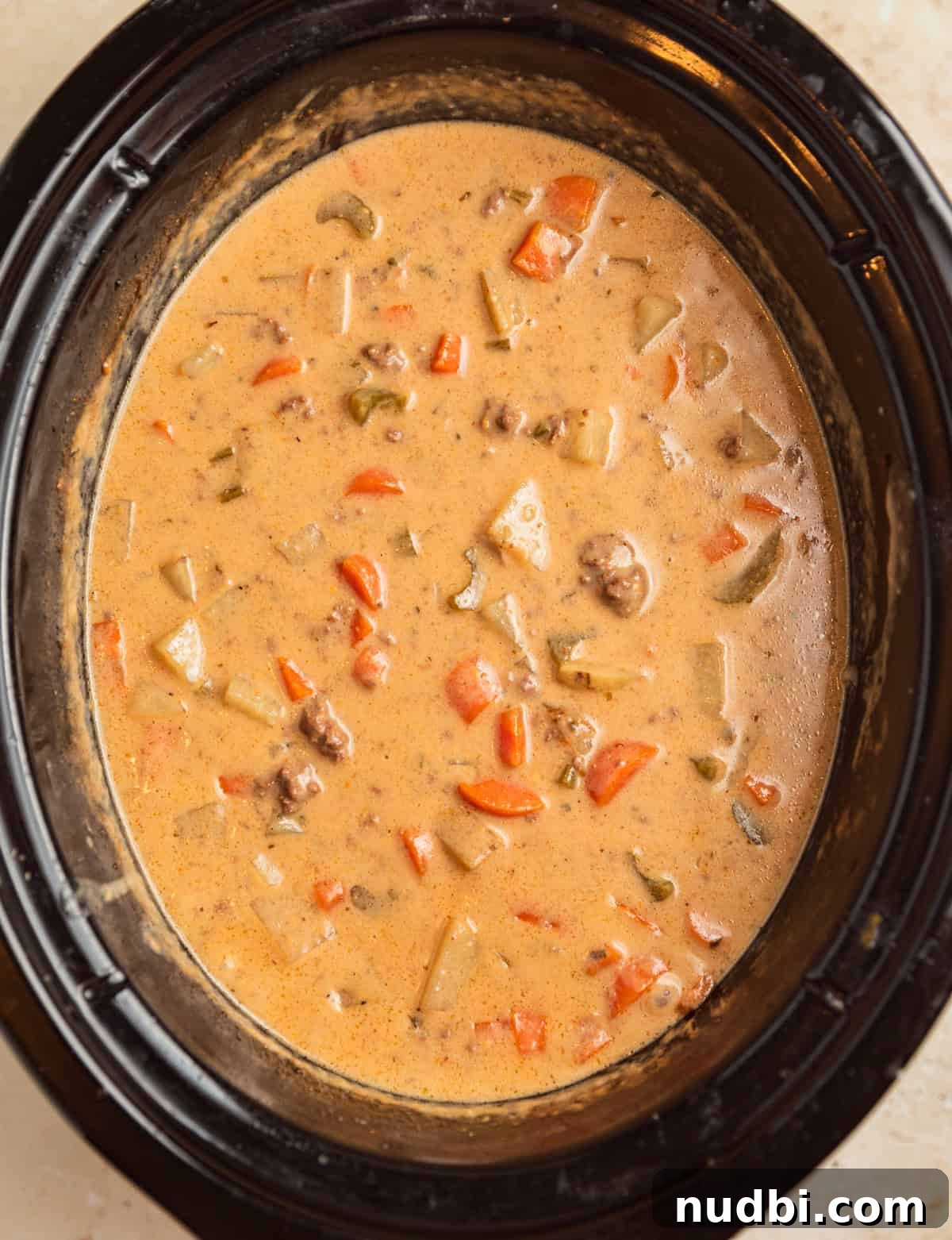 Slow Cooker Cheeseburger Soup Recipe for Weeknight Dinners 10 Crockpot cheeseburger soup in slow cooker after cheese is melted into the soup.