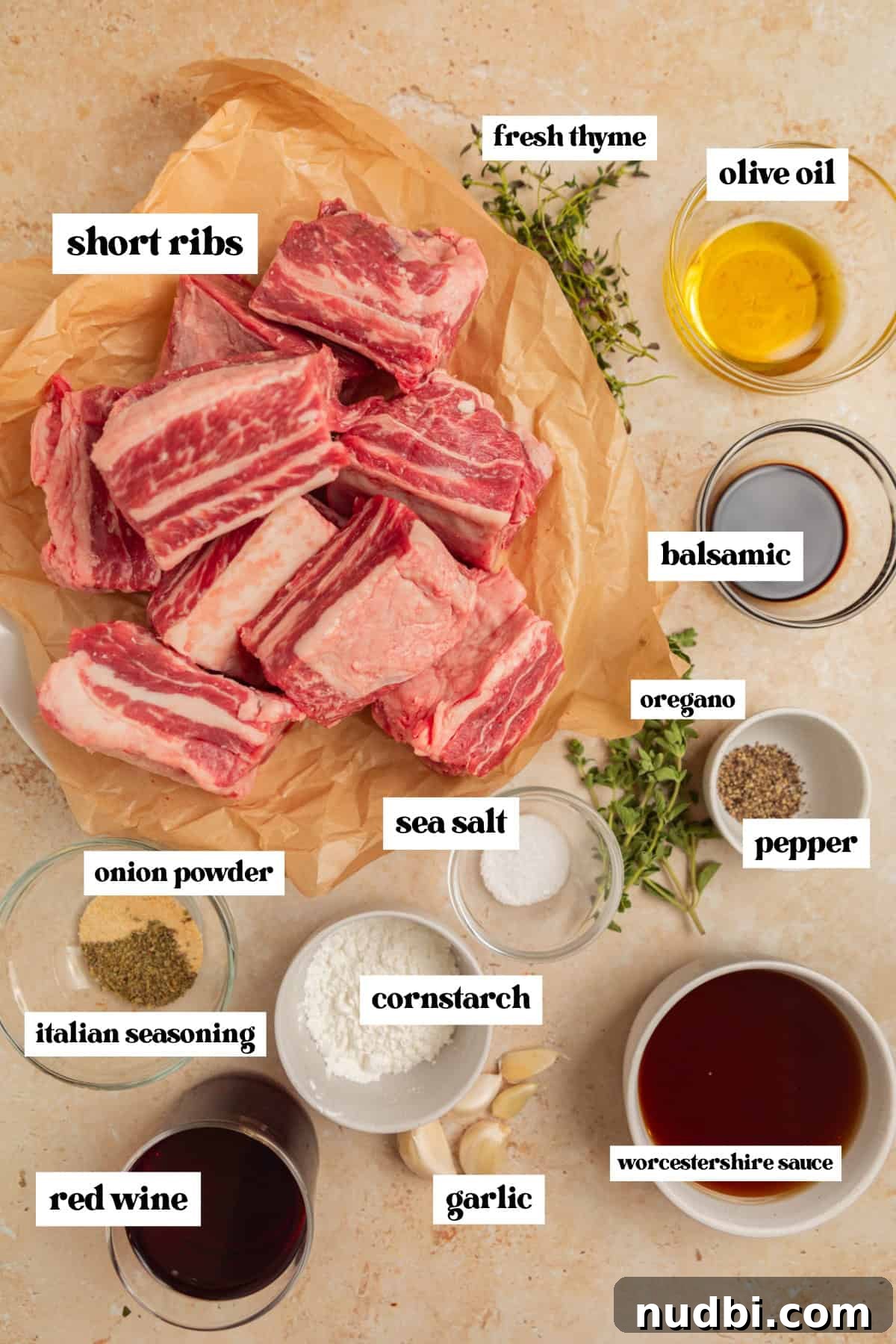 Slow-Cooker Red Wine Braised Short Ribs for Dinner 4 Short ribs in parchment, olive oil, red wine, and other ingredients arranged on surface.
