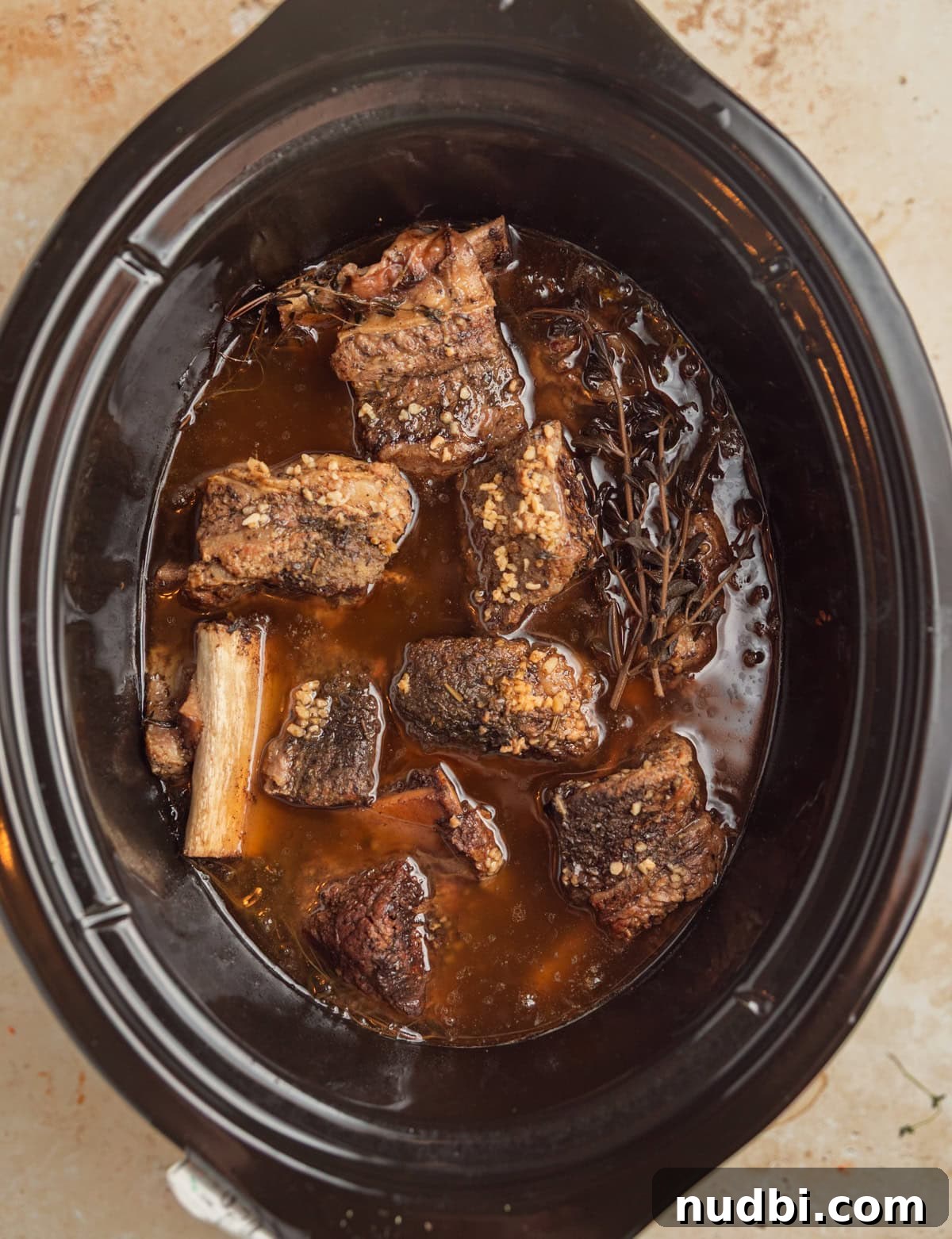 Slow-Cooker Red Wine Braised Short Ribs for Dinner 8 Cooked short ribs in juices.