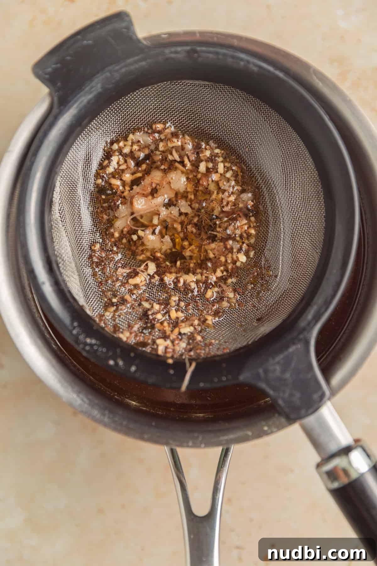 Slow-Cooker Red Wine Braised Short Ribs for Dinner 9 Strainer over saucepan catching drippings.