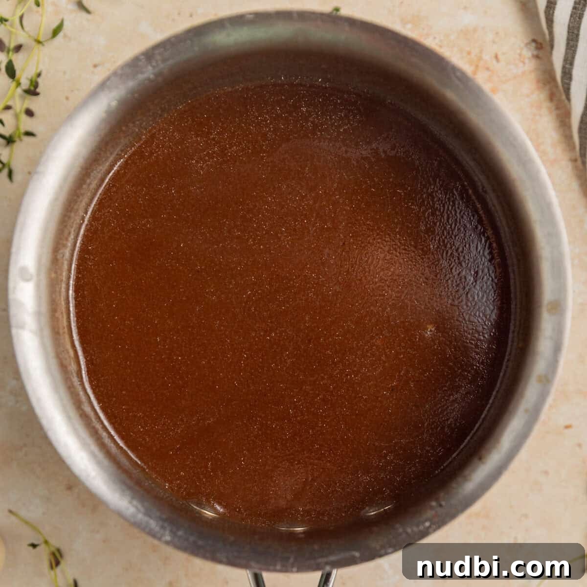 Slow-Cooker Red Wine Braised Short Ribs for Dinner 10 Saucepan with brown gravy.