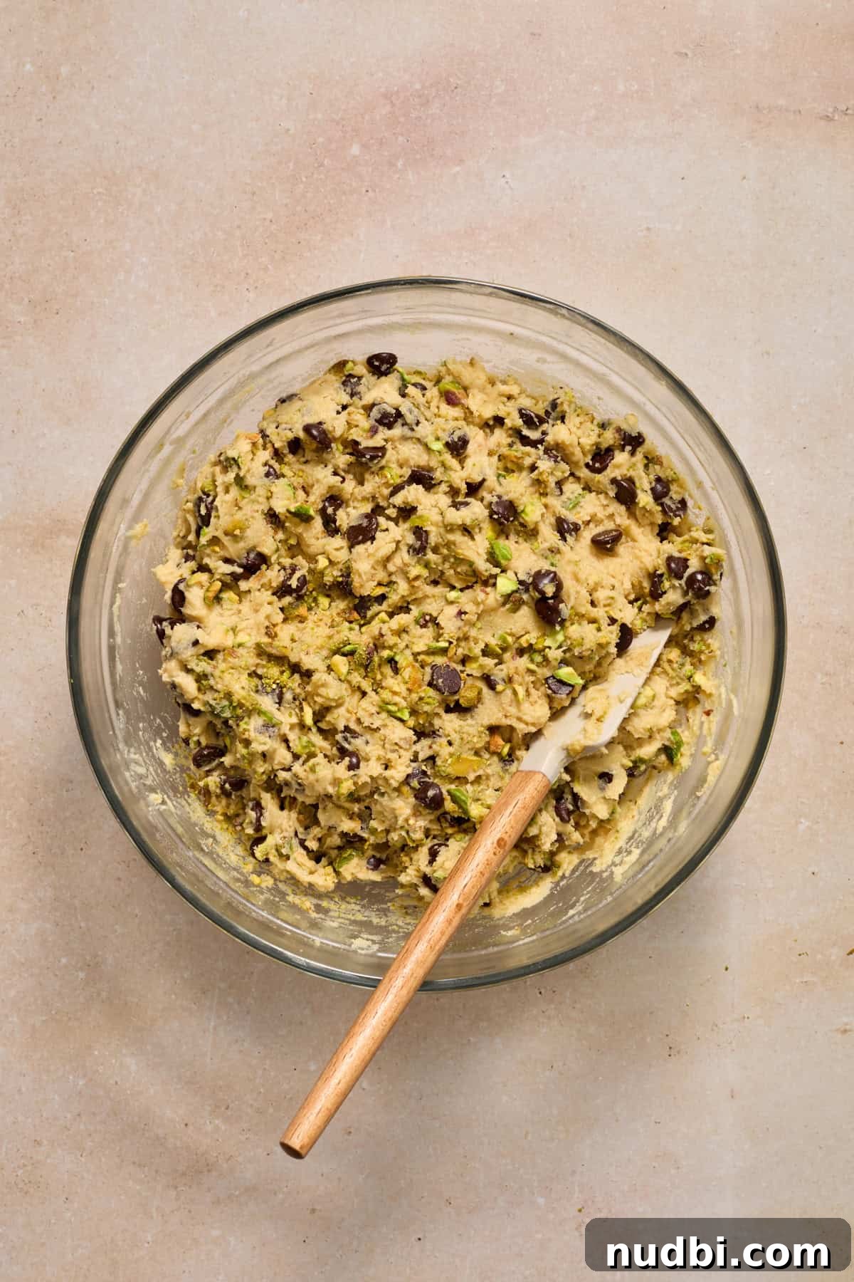 Chewy Pistachio Chocolate Chip Cookies Recipe for Home Bakers 12 Pistachio chocolate chip cookie dough in bowl with spatula.