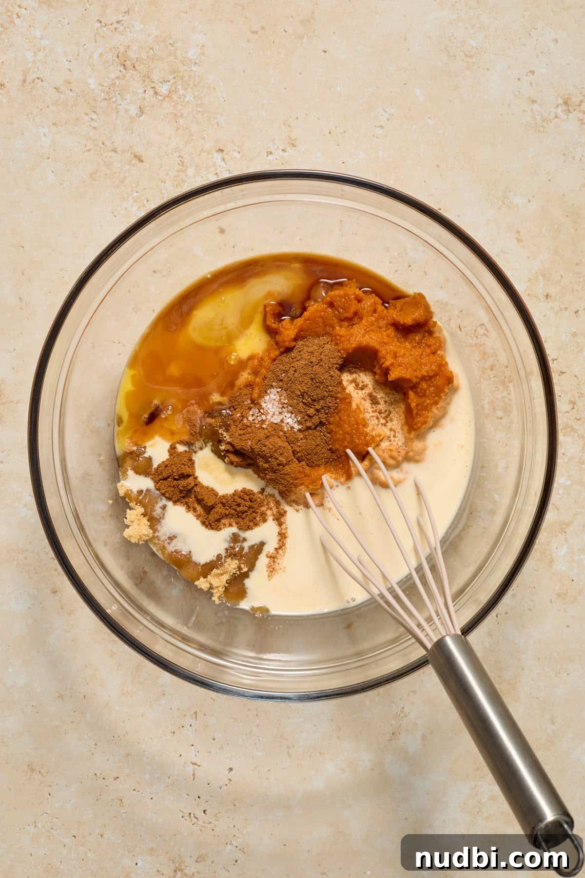 Mini Pumpkin Pies Recipe: Perfect Individual Pumpkin Tarts 5 Pumpkin, evaporated milk, butter and other ingredients in bowl with whisk.