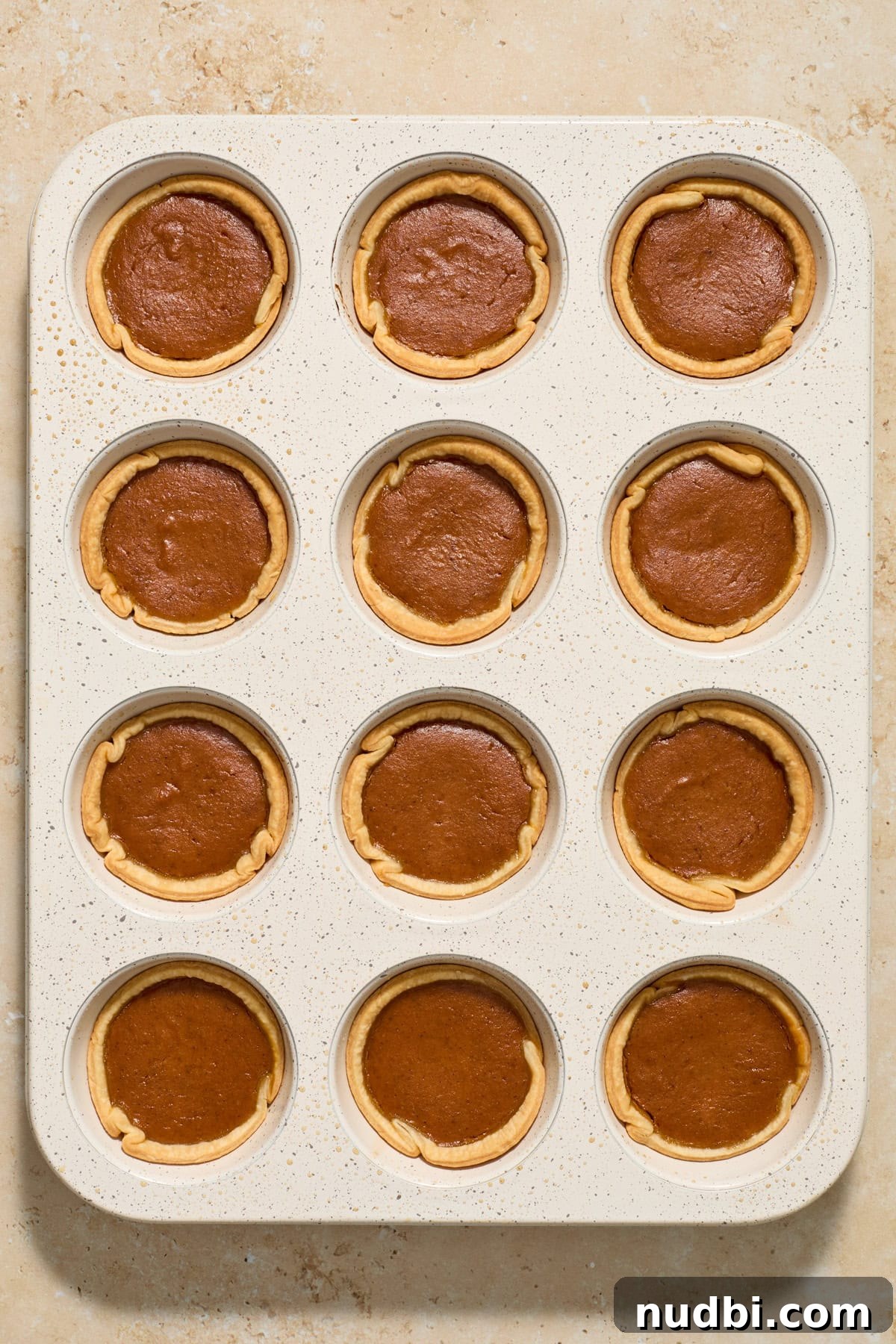 Mini Pumpkin Pies Recipe: Perfect Individual Pumpkin Tarts 10 Muffin tin with mini pumpkin pies after baking.
