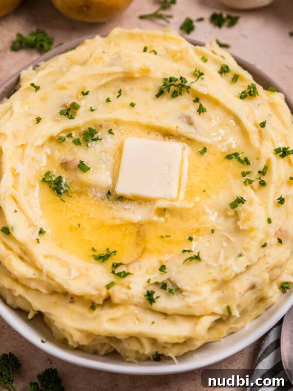 Creamy Gruyère Scalloped Potatoes with Garlic and Thyme 13 Garlic parmesan mashed potatoes in serving dish with melted butter over top.
