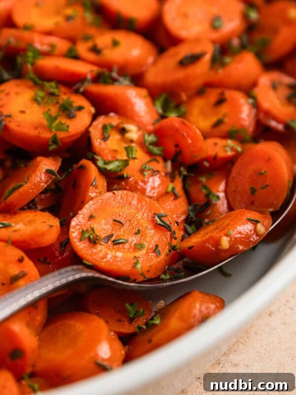 Creamy Gruyère Scalloped Potatoes with Garlic and Thyme 15 Serving spoon scooping into carrots in white dish.