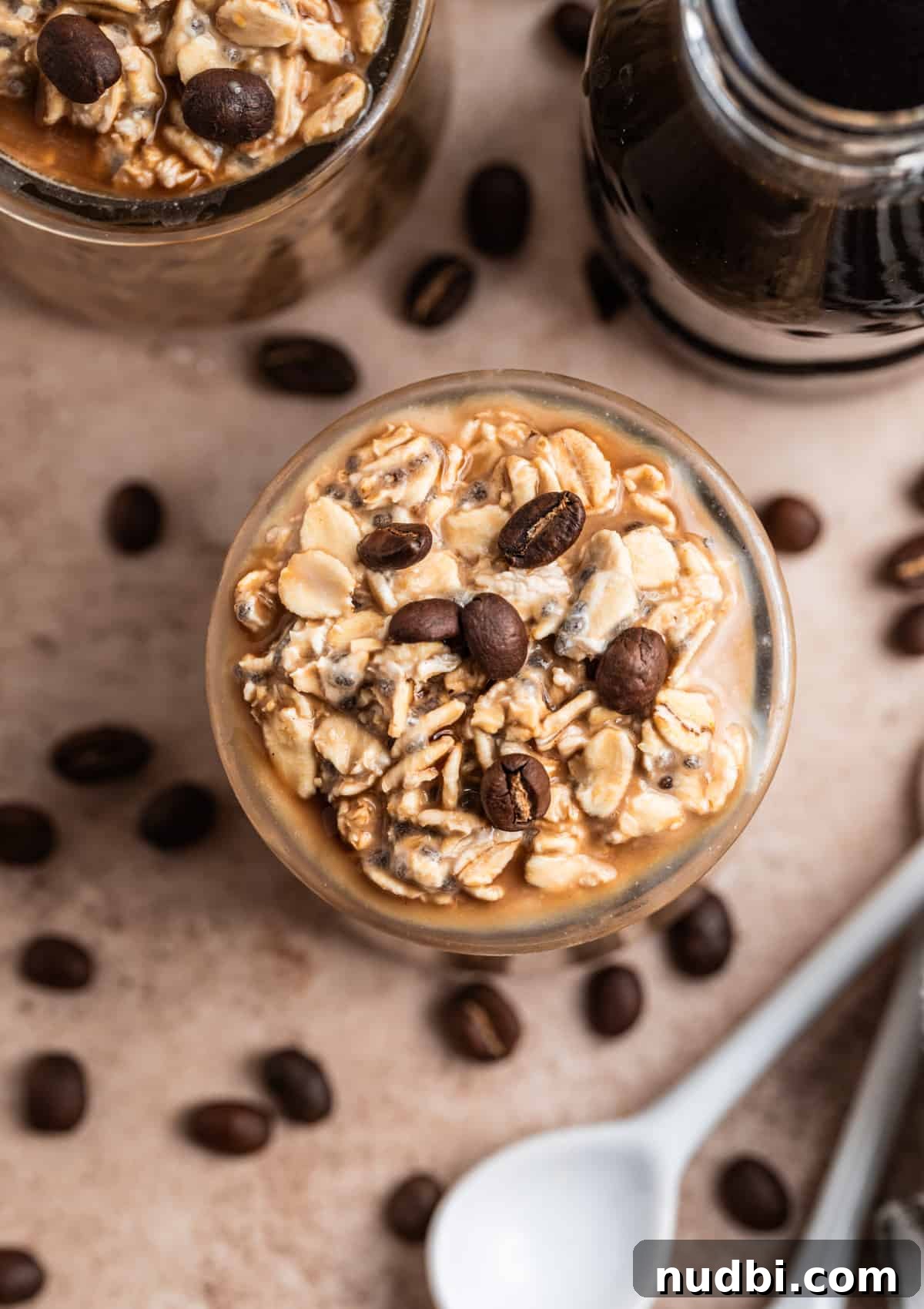 Vanilla Cold Brew Overnight Oats Recipe for Creamy Morning Energy 3 Overhead view of oatmeal in jar with cold brew in jar beside it and spoons laying on the other side.
