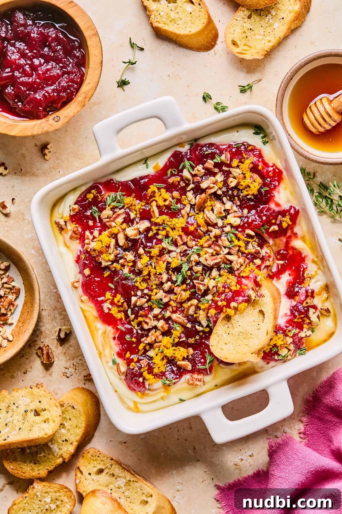 Creamy Whipped Ricotta Dip Recipe for Entertaining 2 Whipped ricotta dip with honey, cranberry sauce, pecans and other garnish in dish with bread.