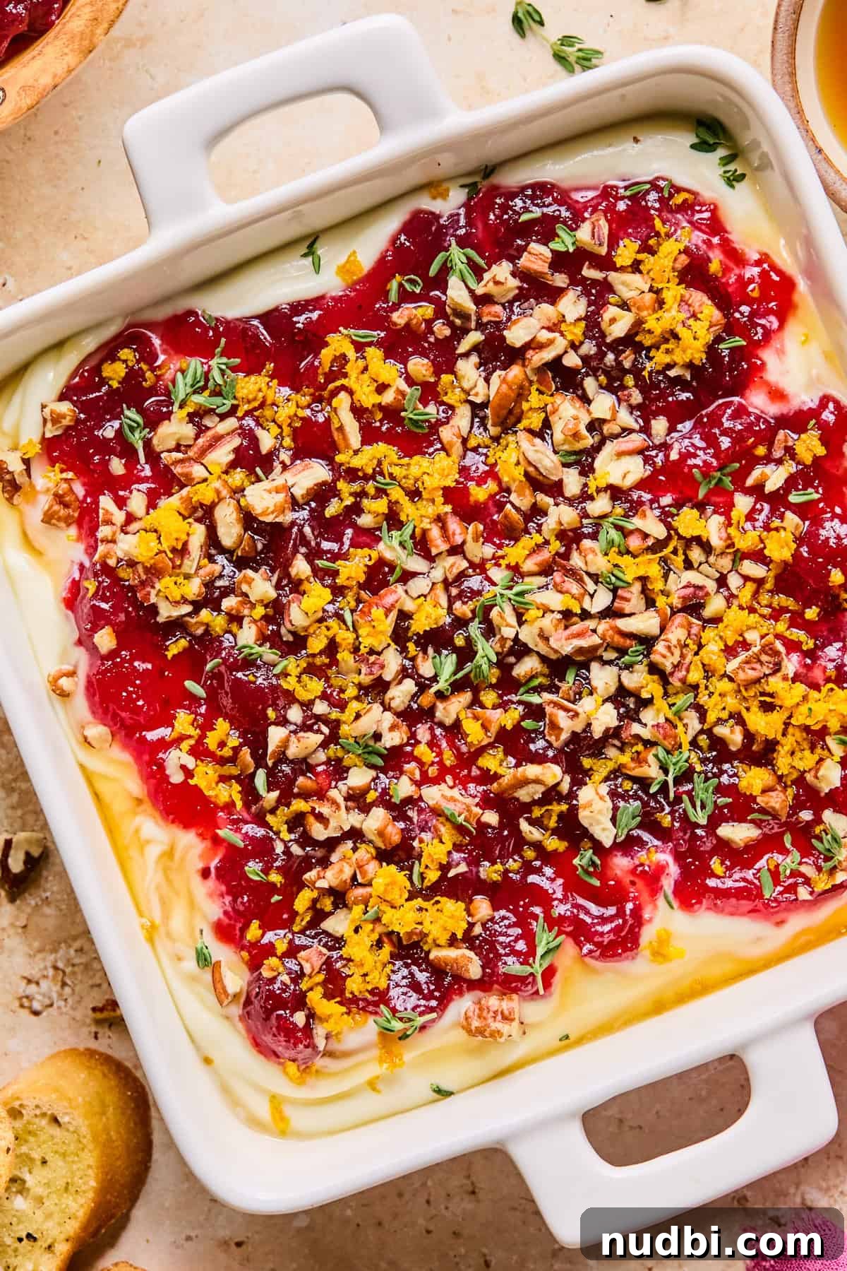 Creamy Whipped Ricotta Dip Recipe for Entertaining 10 Ricotta dip in dish with cranberry sauce, pecans, thyme and orange zest over top.