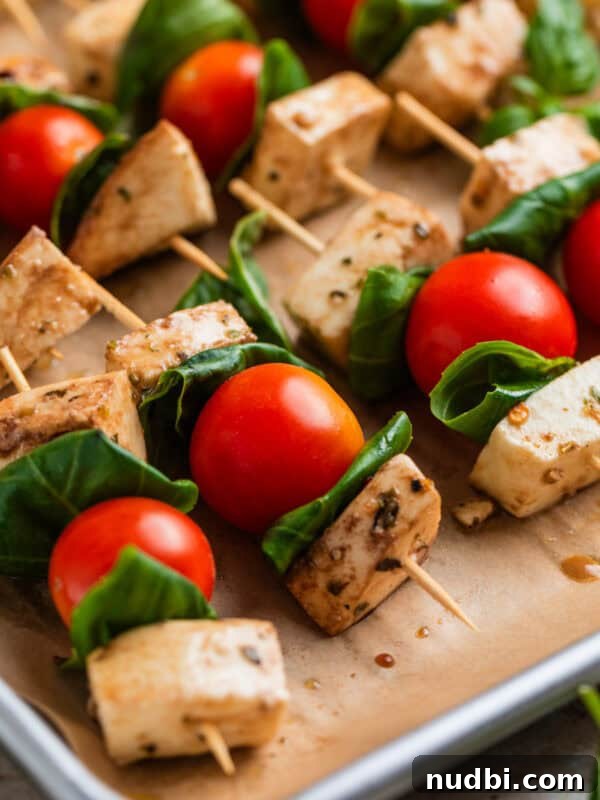 Crispy Goat Cheese Puff Pastry Tart Recipe 11 Tomato, basil mozzarella skewers lined up on parchment lined pan.