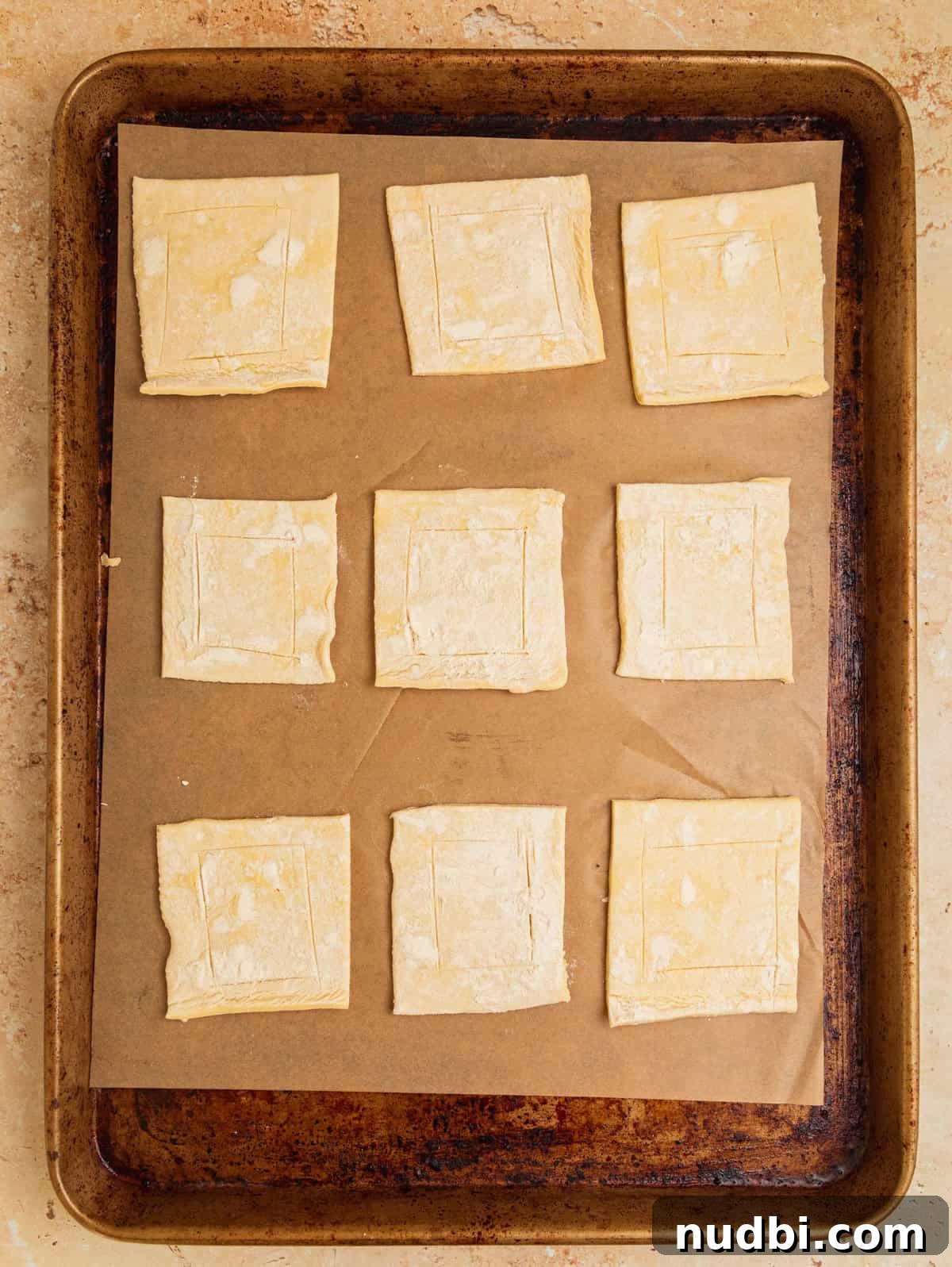 Crispy Goat Cheese Puff Pastry Tart Recipe 5 Sheet pan with parchment paper with puff pastry squares arranged.