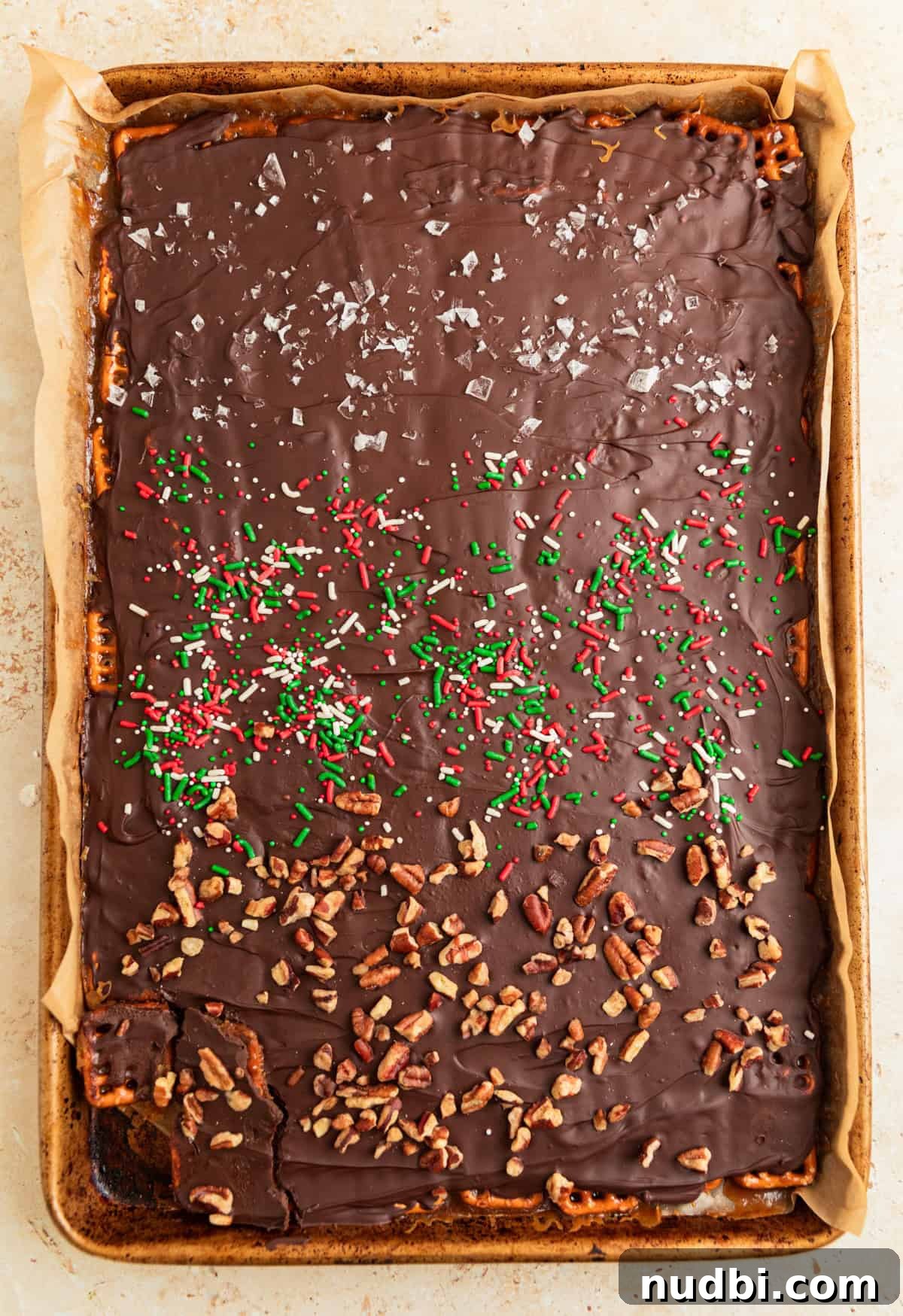 Salted Pretzel Toffee Crunch: Sweet and Salty Candy Recipe 12 Chilled pretzel toffee with pecans, sea salt and red and green sprinkles over top.