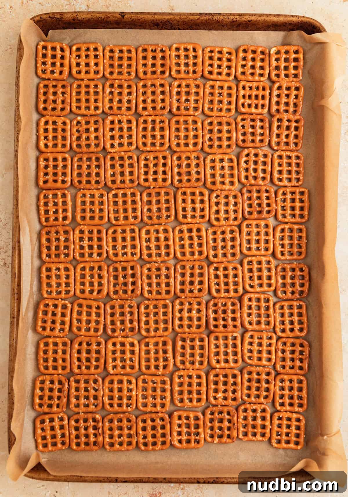 Salted Pretzel Toffee Crunch: Sweet and Salty Candy Recipe 5 Pretzels lined up to make a grid on parchment lined sheet pan.