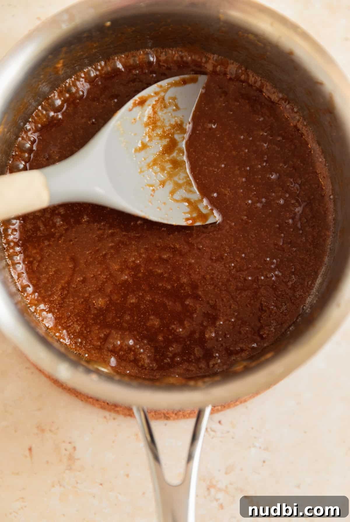 Salted Pretzel Toffee Crunch: Sweet and Salty Candy Recipe 7 Caramel mixture bubbling in sauce pan with spoon.