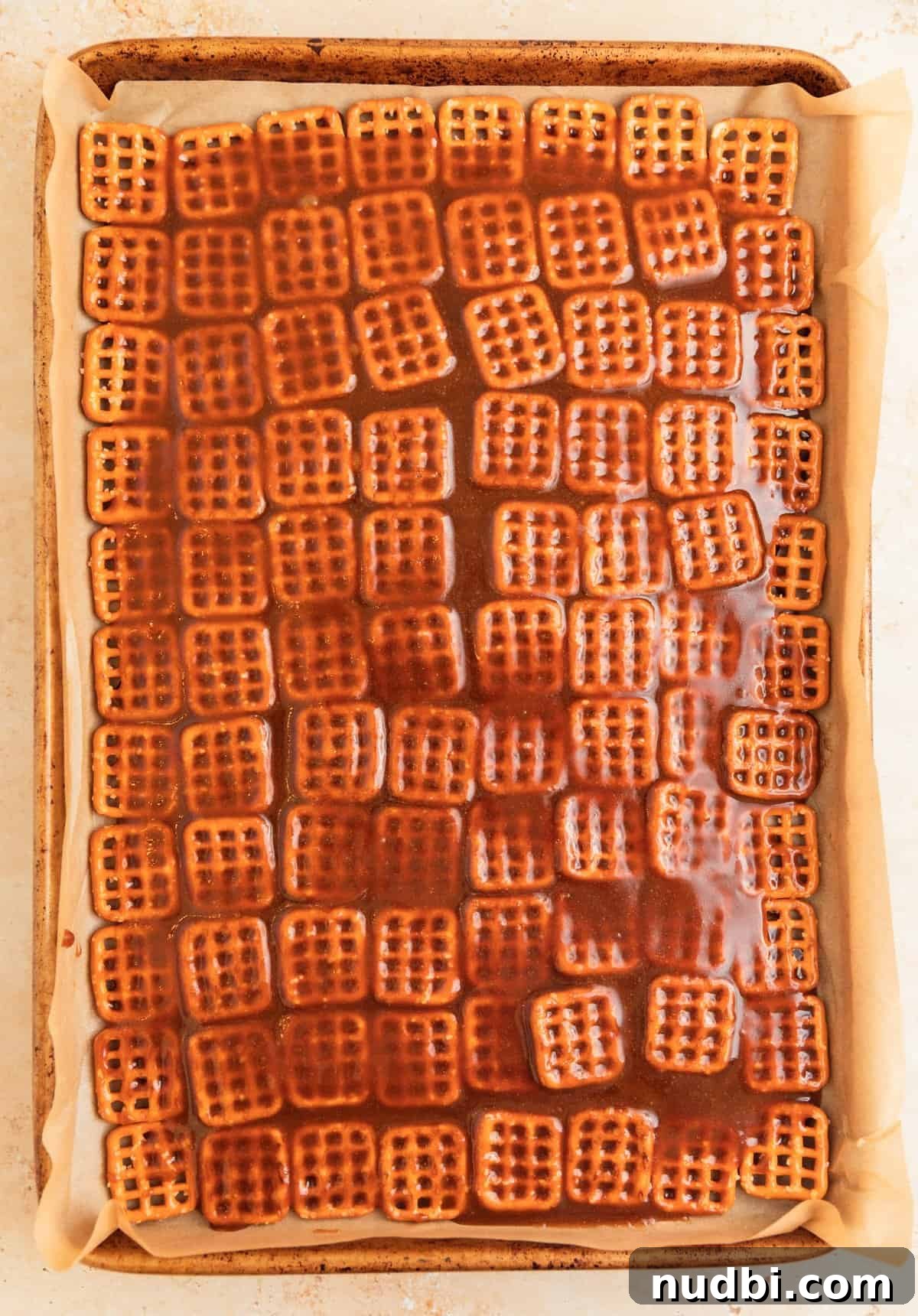 Salted Pretzel Toffee Crunch: Sweet and Salty Candy Recipe 8 Caramel poured over pretzels lined on parchment.