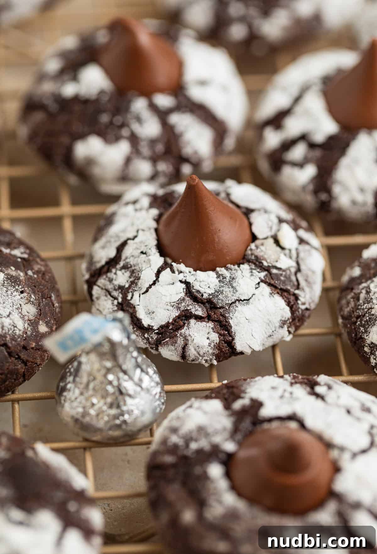 Chocolate Crinkle Blossom Cookies Recipe: Soft Fudgy Chocolate Blossoms 2 Chocolate crinkle cookies with hershey kiss centers on wire rack.