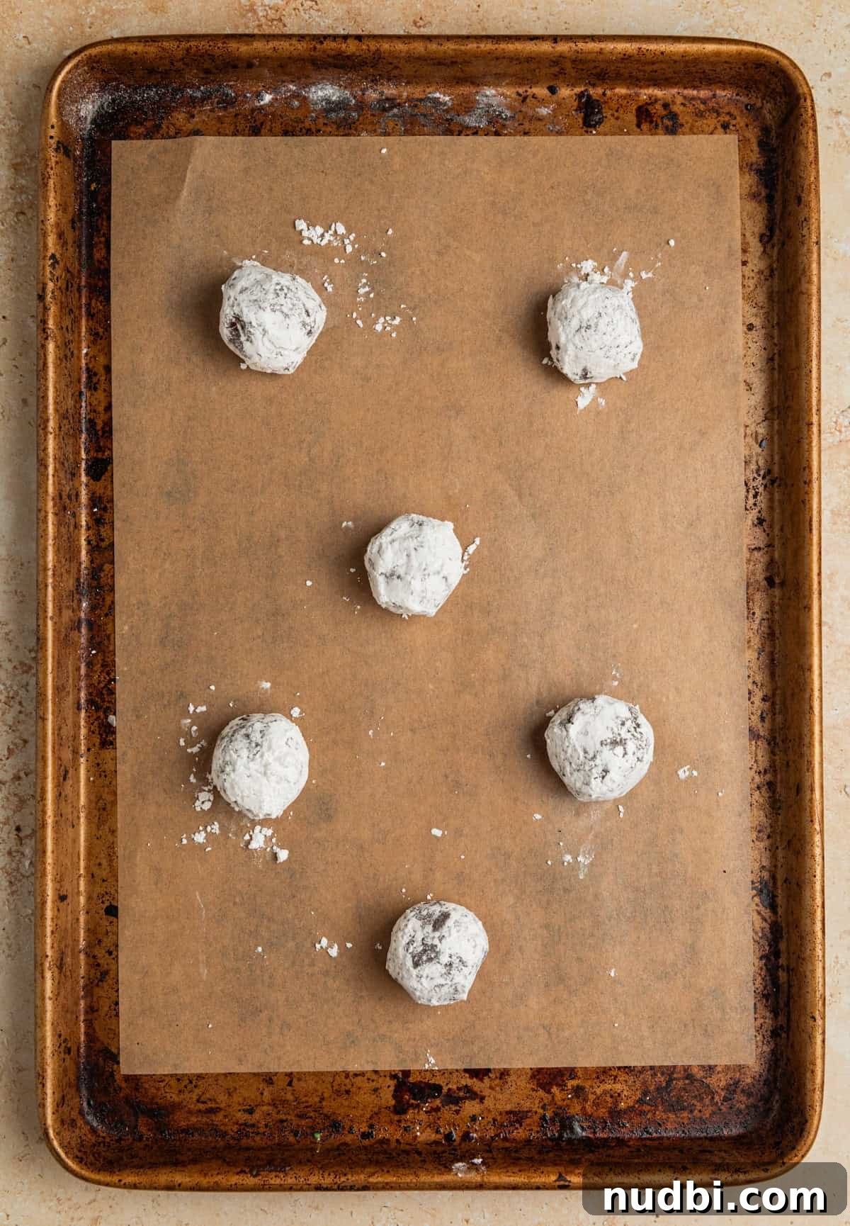Chocolate Crinkle Blossom Cookies Recipe: Soft Fudgy Chocolate Blossoms 7 Powdered sugar covered chocolate cookie dough balls on parchment lined pan.