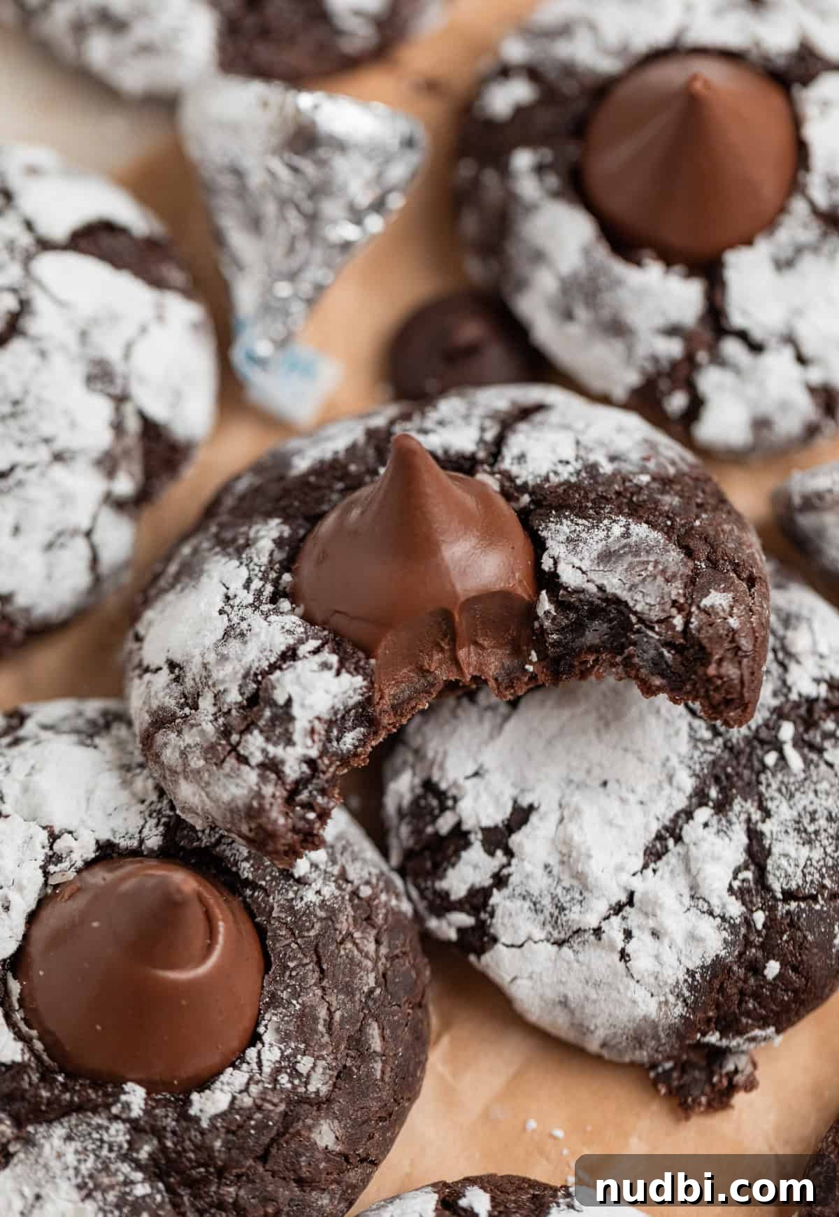 Chocolate Crinkle Blossom Cookies Recipe: Soft Fudgy Chocolate Blossoms 10 Chocolate blossom cookies with bite taken out of one cookie.