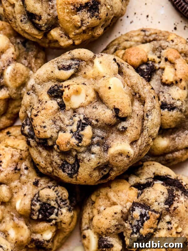 Brownie Crinkle Cookies Recipe — Fudgy, Chewy Chocolate Treats 12 Oreo chocolate chip cookies arranged on surface with white chocolate chips and crumbs around them.