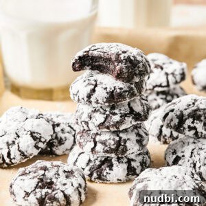 Brownie Crinkle Cookies Recipe — Fudgy, Chewy Chocolate Treats 14 Stack of chocolate crinkle cookies with milk glass.