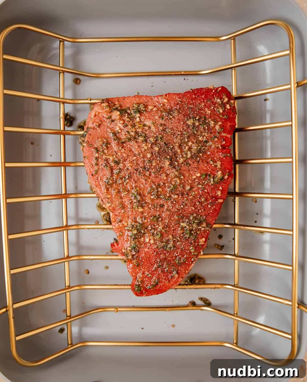 Juicy Top Round Roast Beef Recipe for Tender Slices 7 Roasting pan with top round roast with herb rub coating it before cooking.