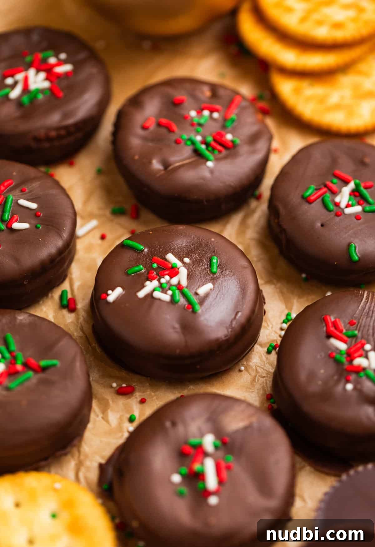 Ritz Cracker Cookies Stuffed with Reese's Cups 9 Chocolate dipped cracker cookies with red and green sprinkles on top.