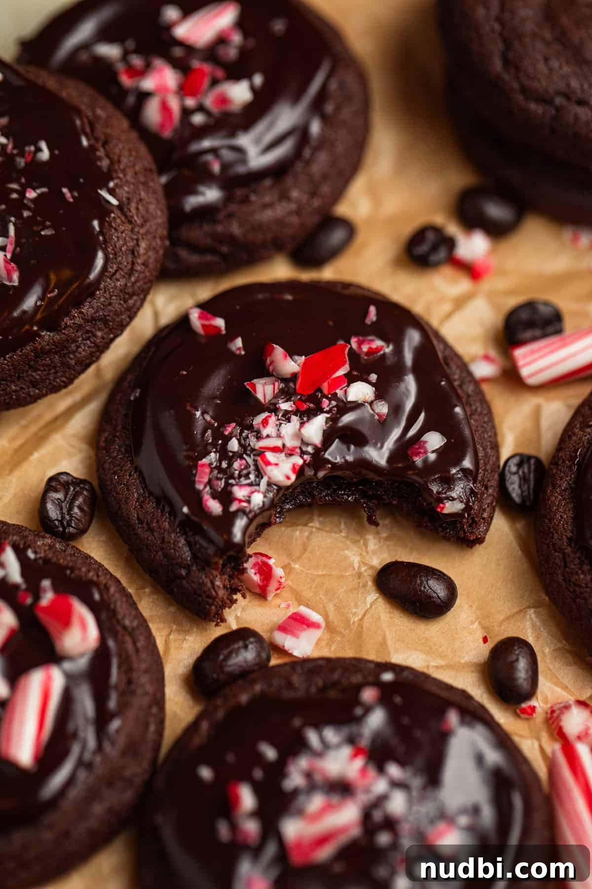 Peppermint Mocha Cookie Recipe — Chocolate Coffee Holiday Cookies 2 Peppermint mocha cookies on parchment with espresso beans and crushed peppermint candy.
