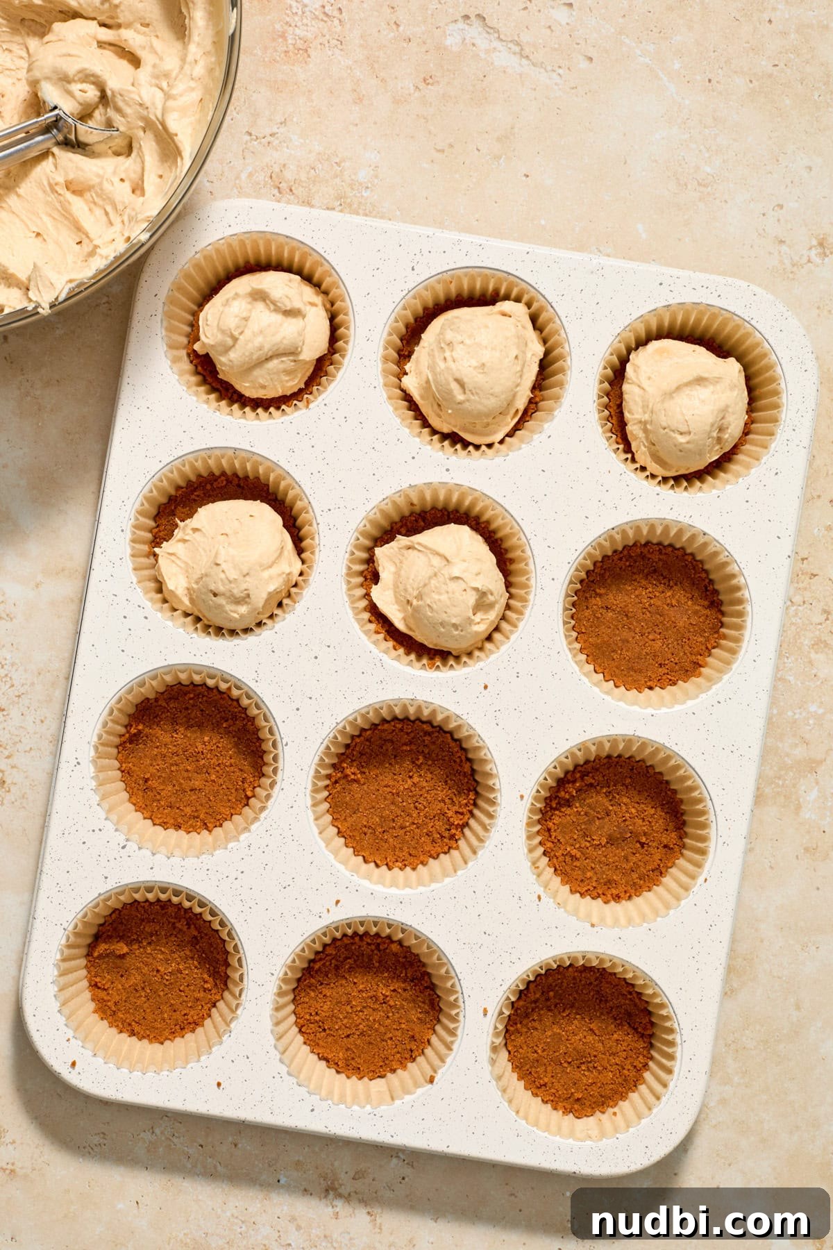 No-Bake Mini Biscoff Cheesecakes Recipe for Crowd-Pleasing Treats 12 Cheesecake added to crust in muffin tin.