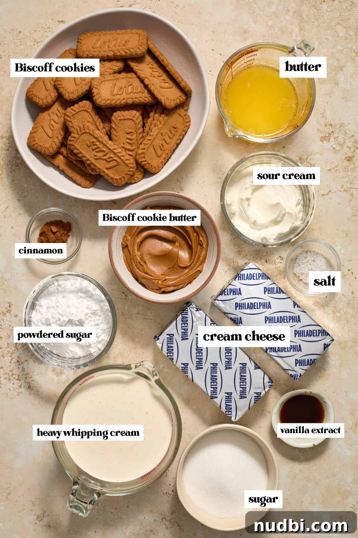 No-Bake Mini Biscoff Cheesecakes Recipe for Crowd-Pleasing Treats 4 Lotus cookies, cream cheese, butter, and other ingredients arranged for recipe.