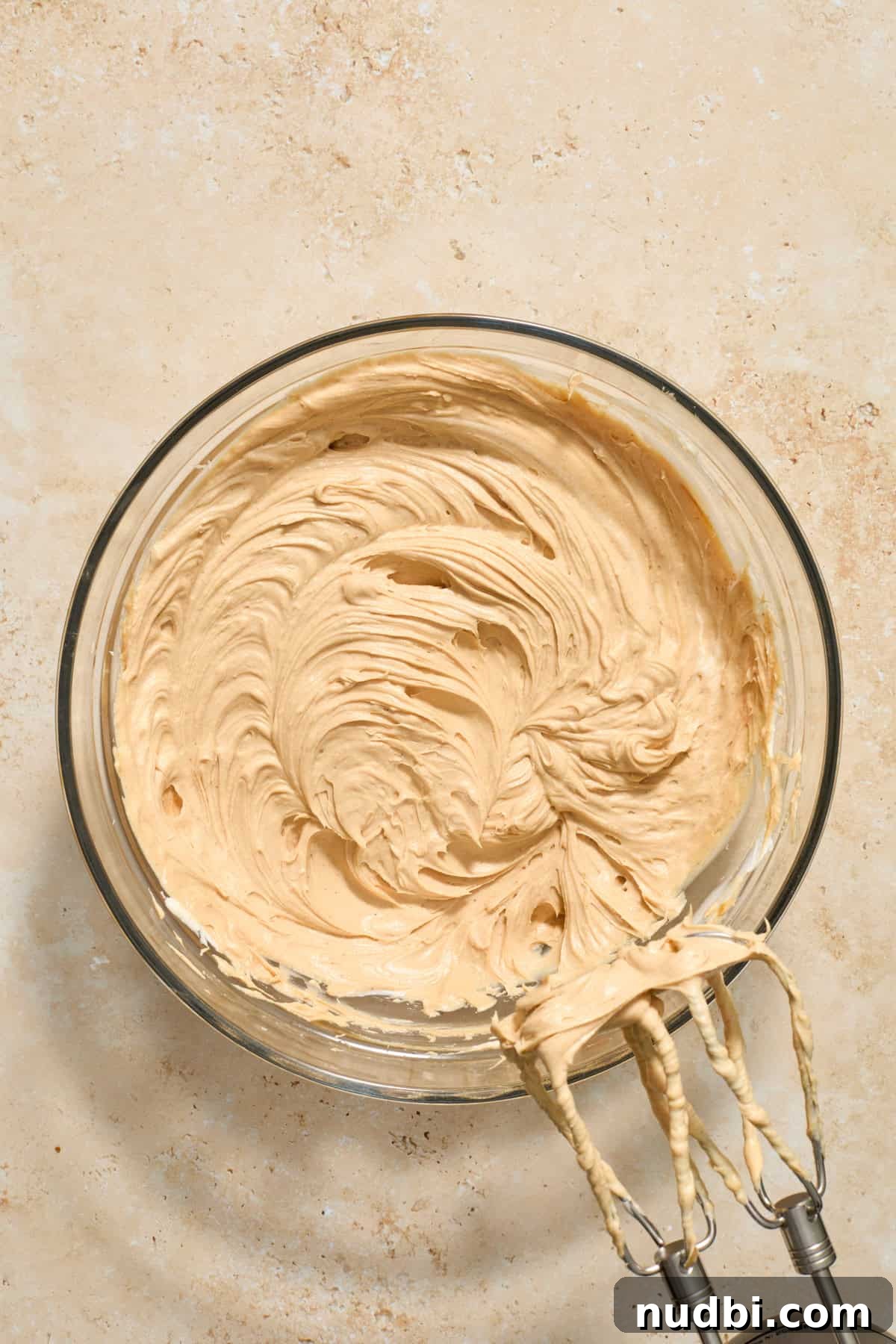 No-Bake Mini Biscoff Cheesecakes Recipe for Crowd-Pleasing Treats 9 Mixed cookie butter cheesecake mixture in bowl.