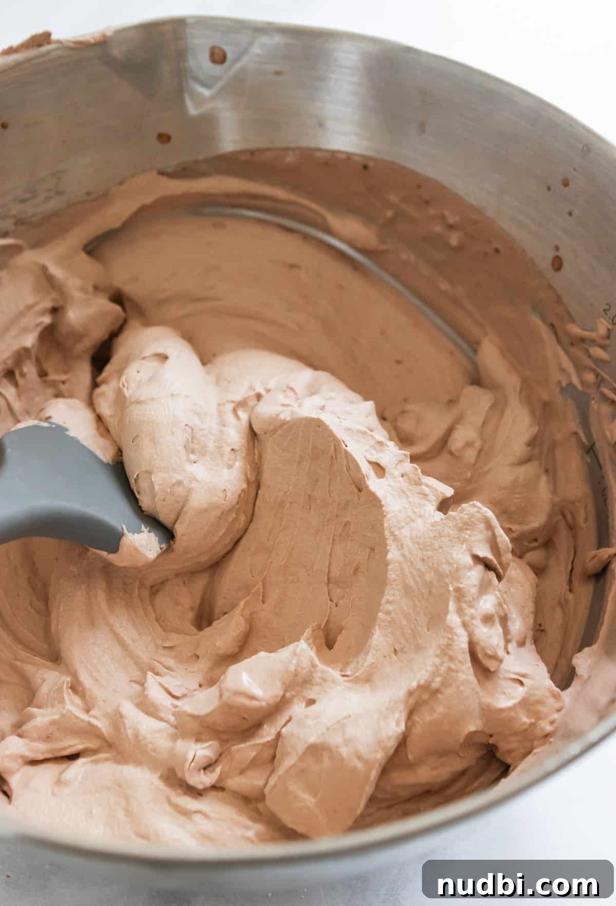 Light and Fluffy Chocolate Whipped Cream Recipe 6 Spatula in silver bowl containing chocolate whipped cream.