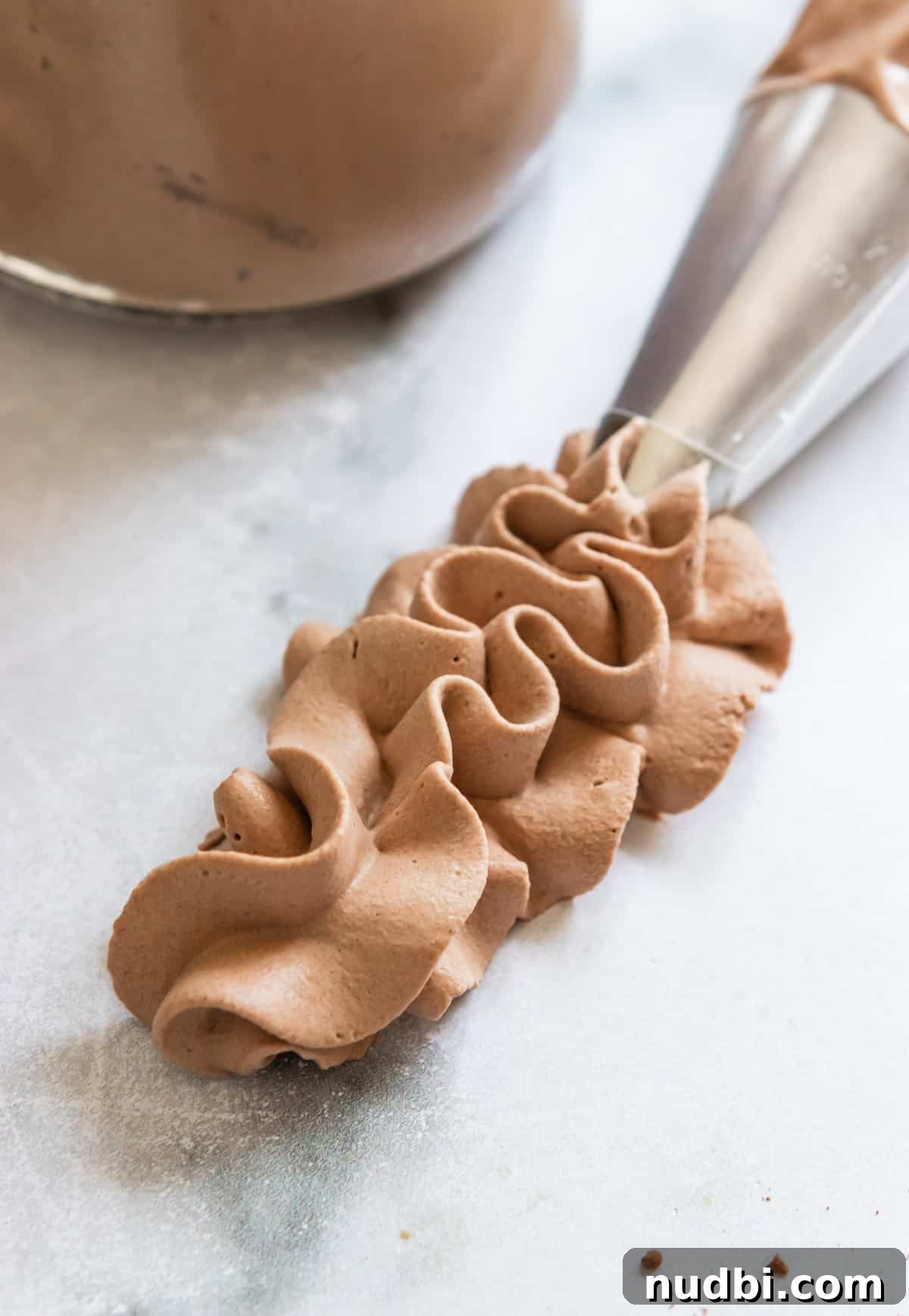 Light and Fluffy Chocolate Whipped Cream Recipe 7 Piped whipped cream with chocolate on counter surface.