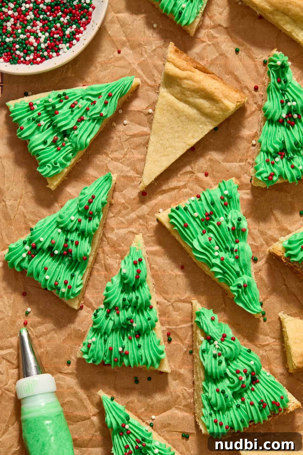 Christmas Sugar Cookie Bars Recipe with Festive Frosting 14 Frosted Christmas sugar cookie bars on parchment.