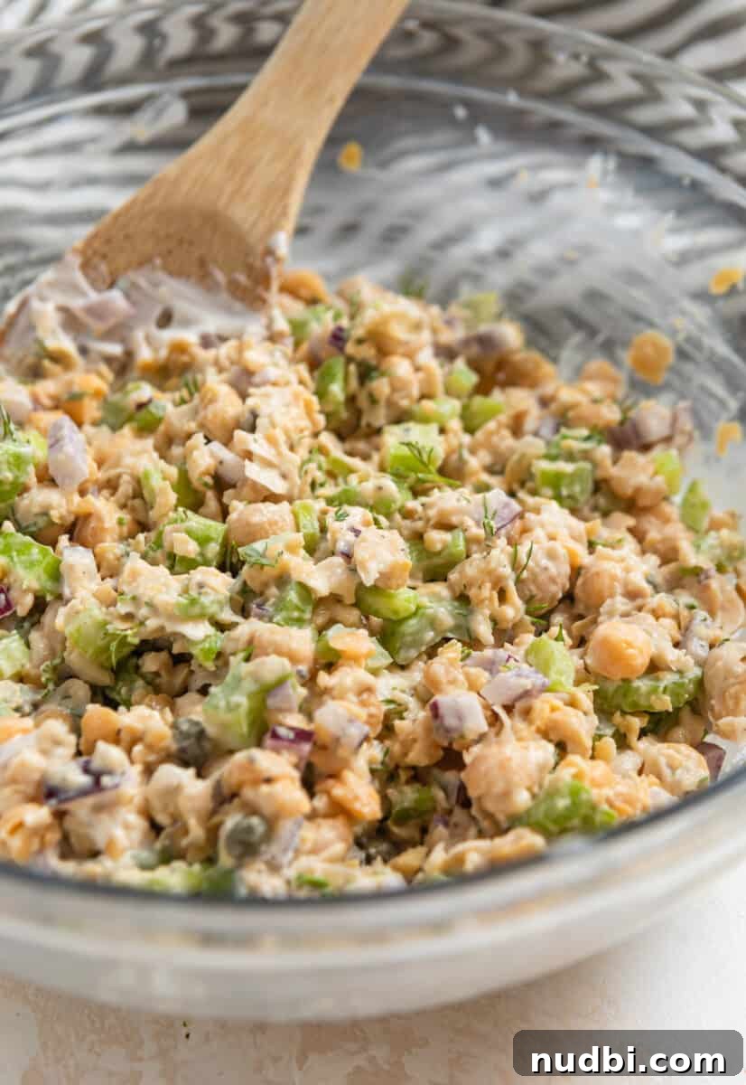 Vegan Chickpea Tuna Salad Recipe — Creamy Plant-Based Lunch 7 Chickpea dill tuna mixed in bowl with wooden spoon.