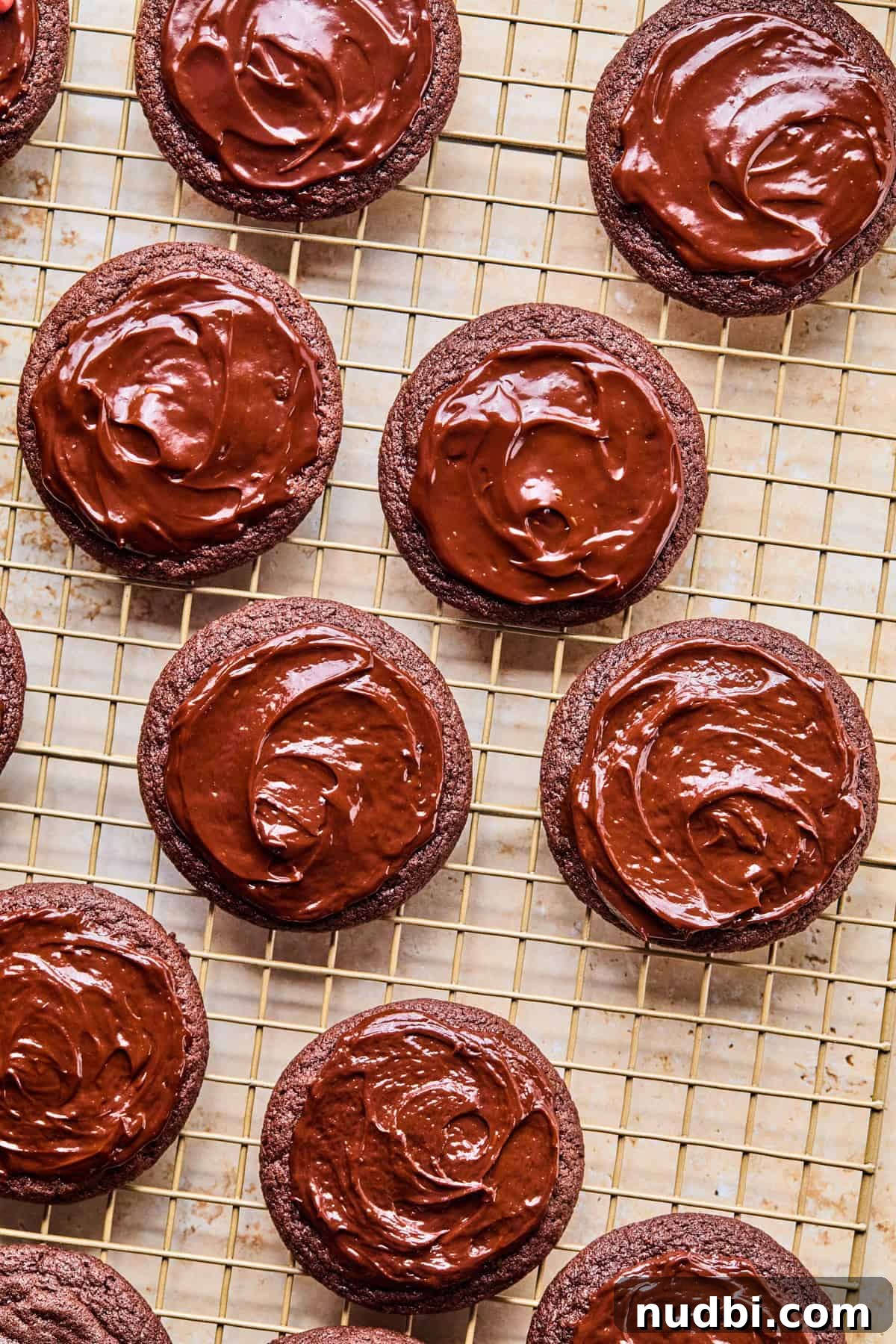 Cosmic Brownie Cookie Recipe: Fudgy, Colorful Chocolate Cookies 14 Chocolate ganache spread on cookies on cooling rack.