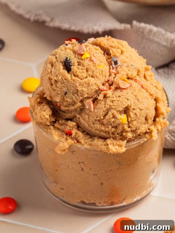 Cosmic Brownie Cookie Recipe: Fudgy, Colorful Chocolate Cookies 18 Glass with edible peanut butter cookie dough scooped into it.