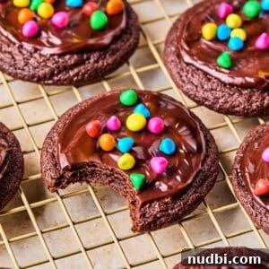 Cosmic Brownie Cookie Recipe: Fudgy, Colorful Chocolate Cookies 20 Cosmic brownie cookies on wire rack with bite taken out.