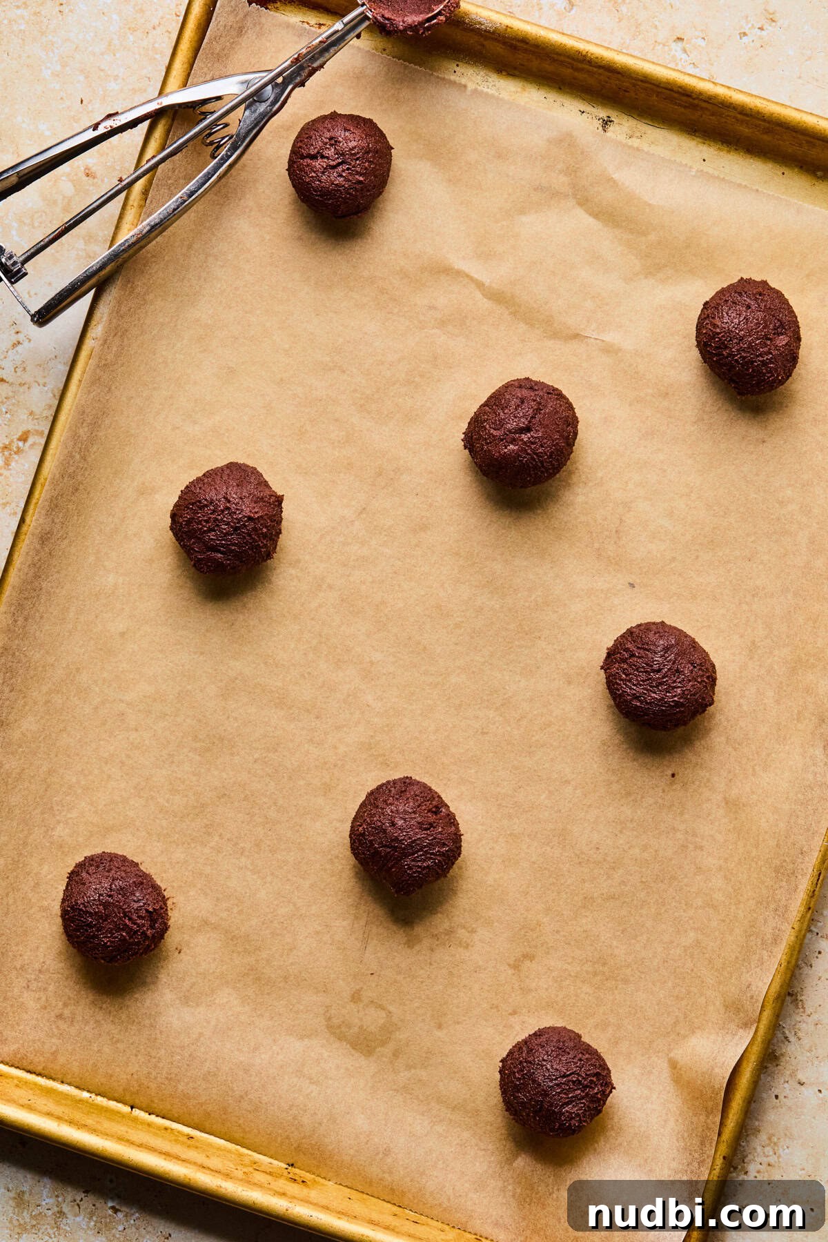Cosmic Brownie Cookie Recipe: Fudgy, Colorful Chocolate Cookies 10 Parchment lined cookie sheet with chocolate cookie dough balls.