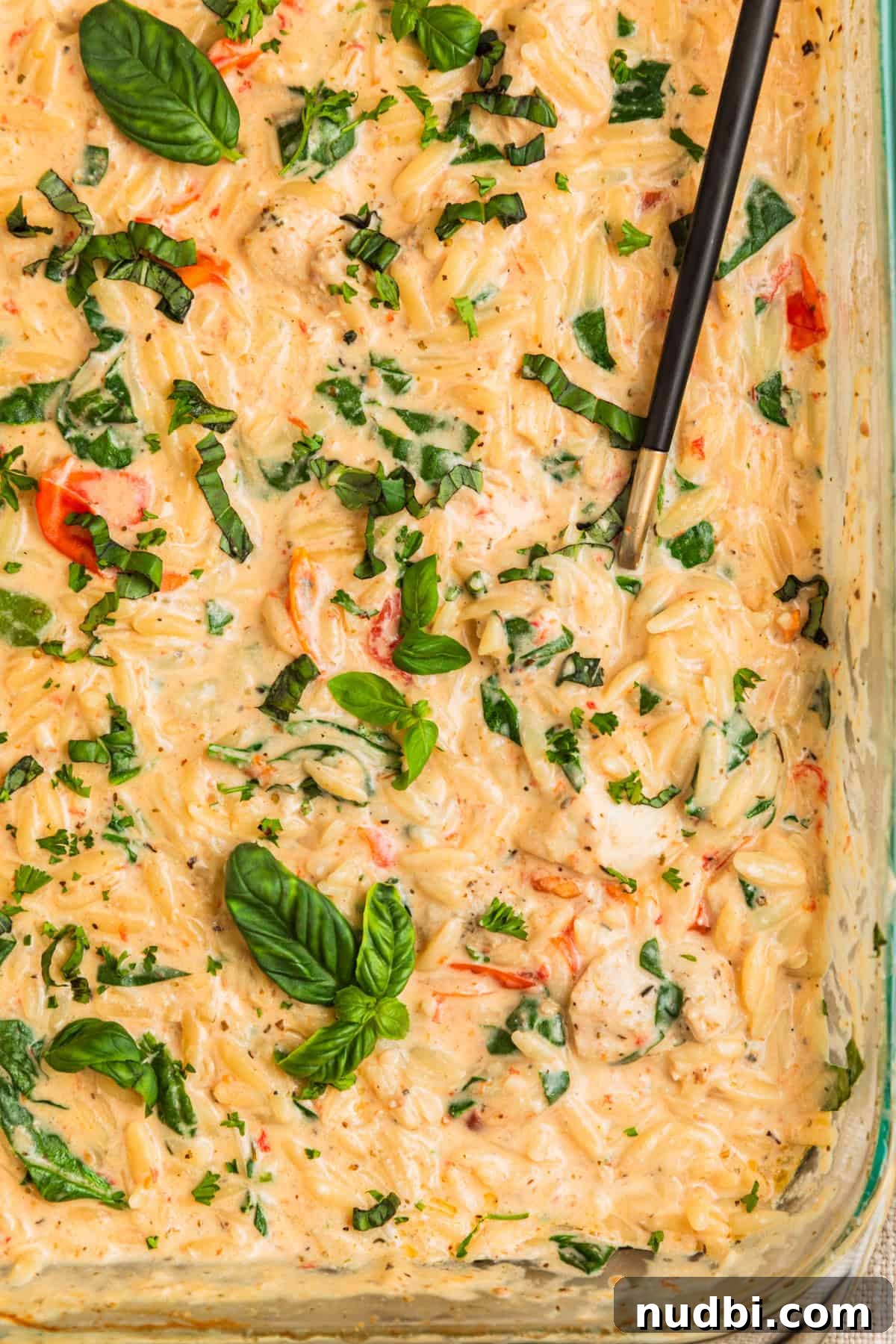 Creamy Baked Chicken and Orzo Casserole for Weeknight Dinners 2 Pan with baked chicken and orzo with basil leaves over top.