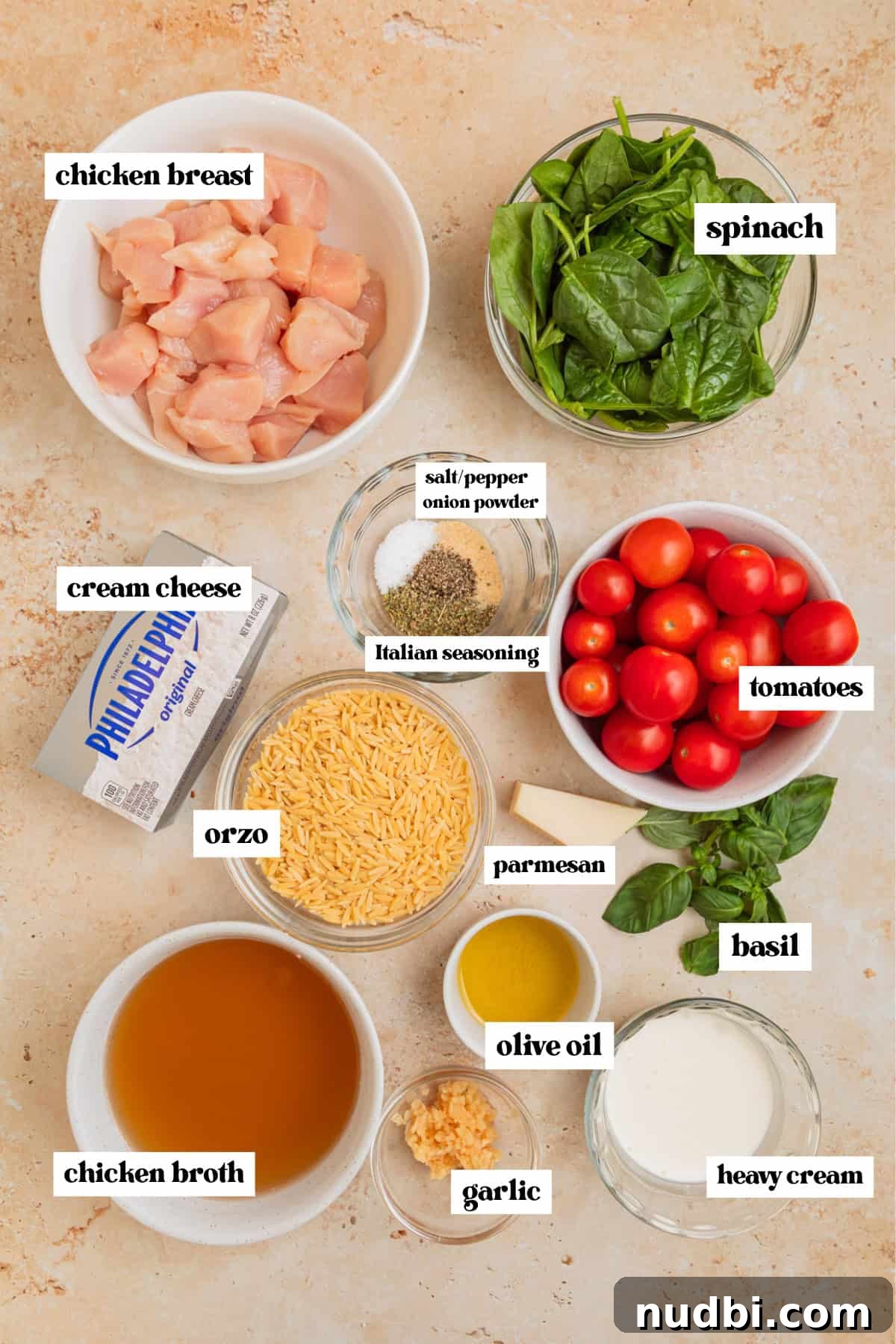 Creamy Baked Chicken and Orzo Casserole for Weeknight Dinners 4 Cubed chicken breast, baby spinach, cream cheese and other labeled ingredients for recipe.