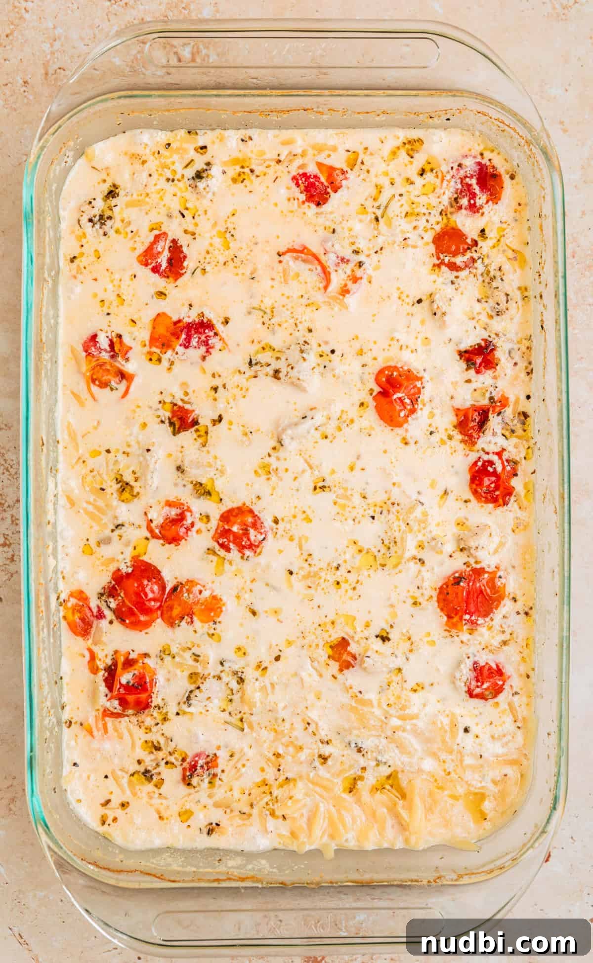 Creamy Baked Chicken and Orzo Casserole for Weeknight Dinners 8 Pan with cream creamy baked chicken and orzo before stirring.