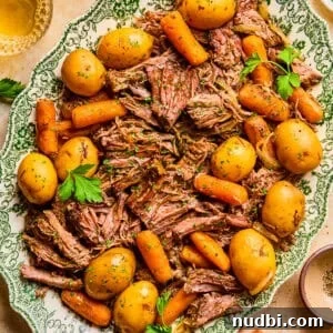 25 Must-Try Recipes Trending in 2025 4 Plate with pot roast served with meat, potatoes and carrots and chopped parsley on top.