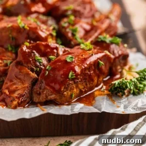 25 Must-Try Recipes Trending in 2025 7 BBQ boneless pork ribs on wax paper lined cutting board topped with chopped fresh parsley.