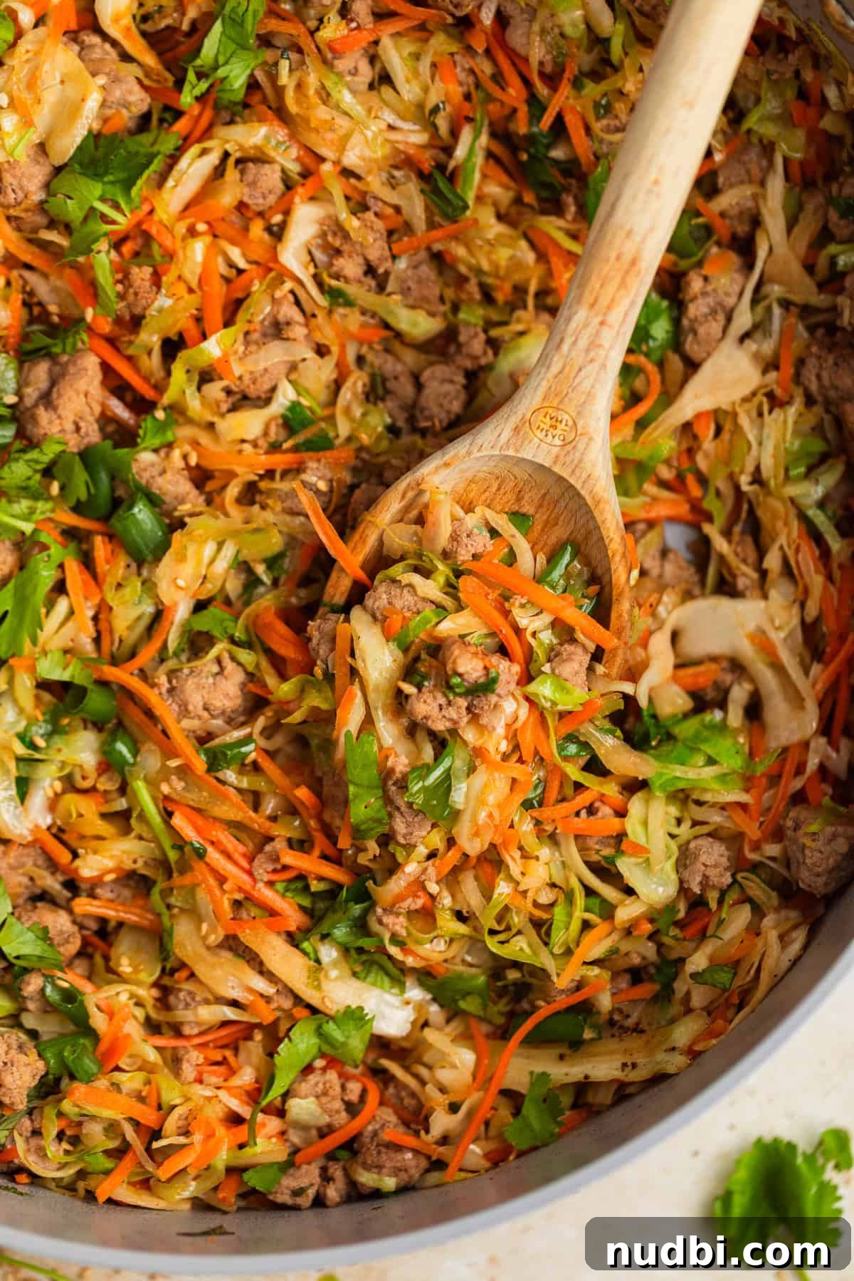 Ground Turkey Egg Roll Bowl Recipe with Asian Slaw 2 Ground turkey egg roll bowl in pot with wooden spoon.