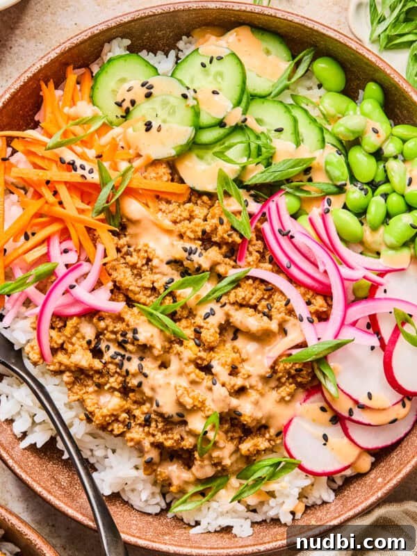 Ground Turkey Egg Roll Bowl Recipe with Asian Slaw 11 Rice bowl with ground turkey, bang bang sauce, cucumber, carrots and other ingredients.