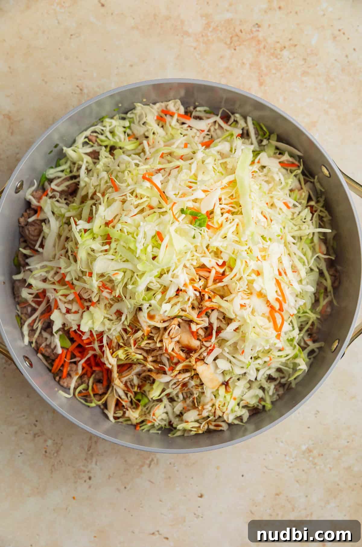 Ground Turkey Egg Roll Bowl Recipe with Asian Slaw 6 Cabbage, carrots and other ingredients added to pan with ground turkey.