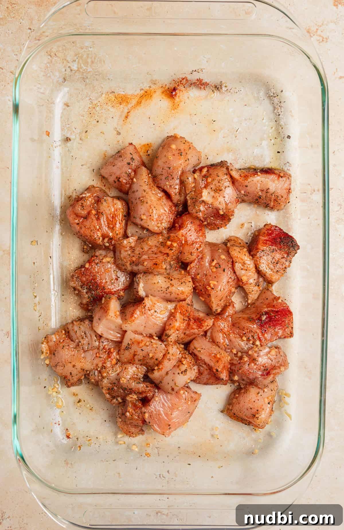 Greek Chicken with Lemon Orzo Pilaf: Flavorful Mediterranean Recipe 5 Chicken pieces in pan tossed in olive oil and seasonings.