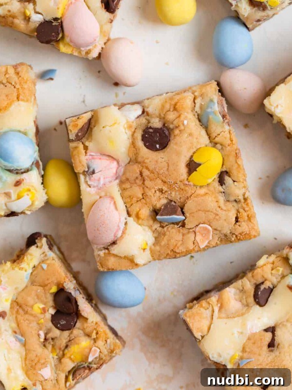 Frosted Sugar Cookie Bars Recipe — Soft, Chewy Dessert Bars 15 Easter mini egg bars arranged on counter with other mini eggs.