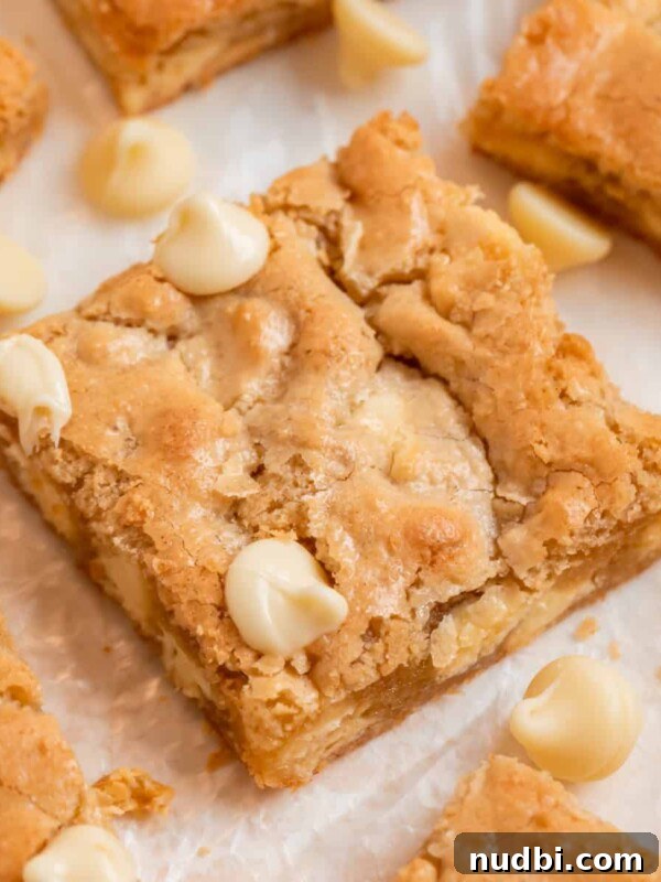 Frosted Sugar Cookie Bars Recipe — Soft, Chewy Dessert Bars 17 Almond flour blondies on parchment with white chocolate chips.