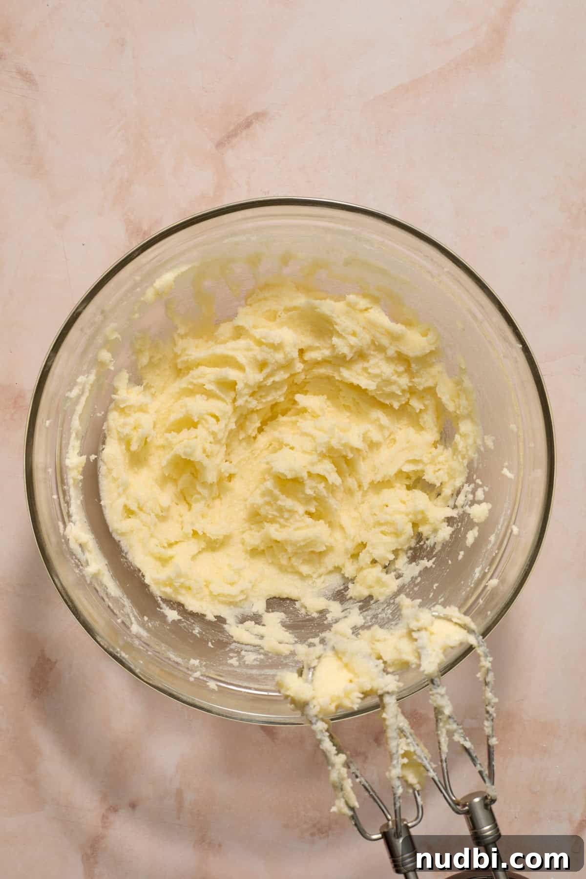 Frosted Sugar Cookie Bars Recipe — Soft, Chewy Dessert Bars 5 Creamed butter and sugar in glass mixing bowl with mixer.